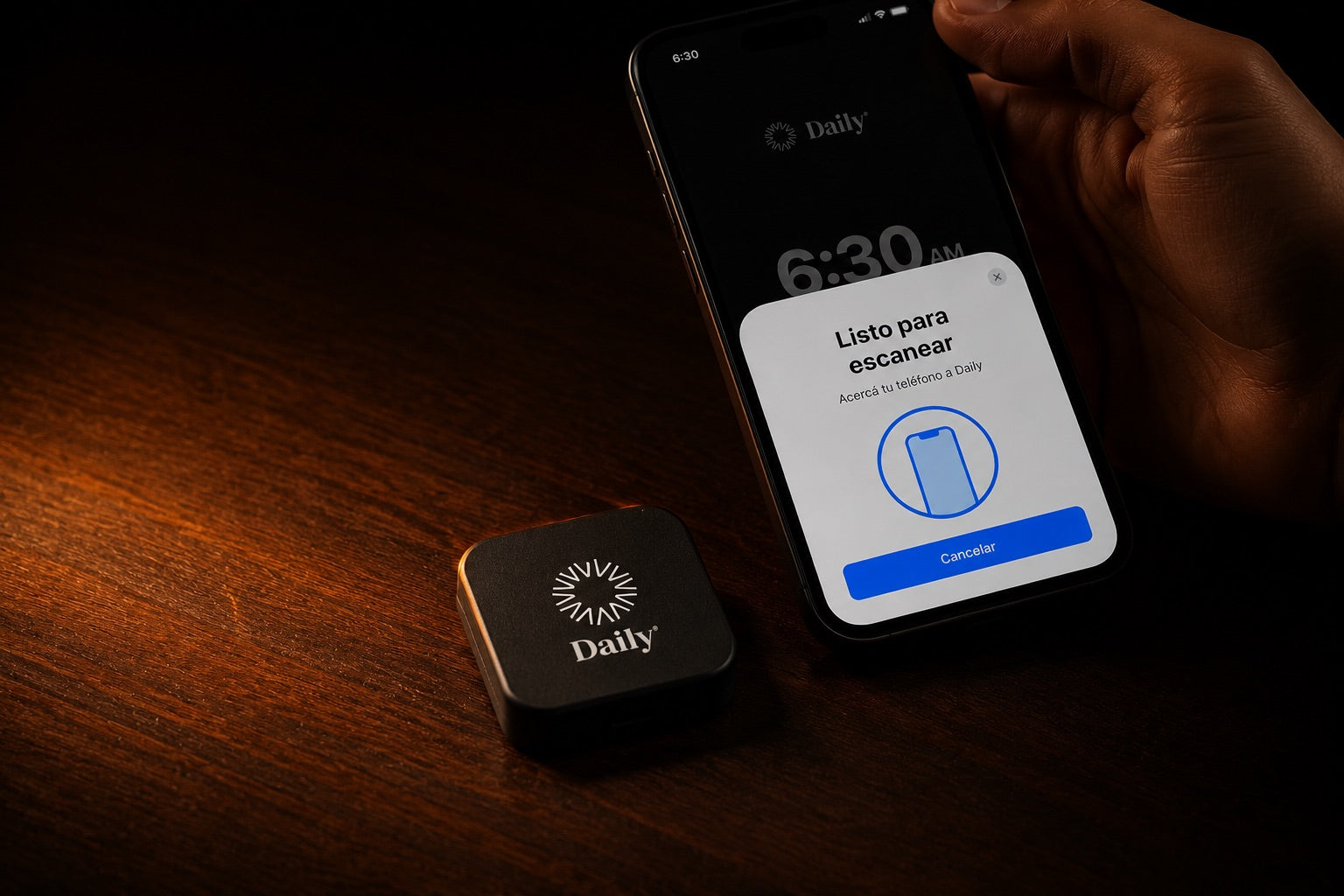 Daily Dock sobre una mesa de madera junto a un celular mostrando la pantalla para escanear y apagar la alarma